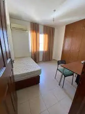 a room with a bed and a table in it at lomez House in Amman