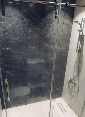 a shower with a glass door in a bathroom at Amman Damac one bedroom boulevard Abdali استديو في داماك عمان الاردن in Amman