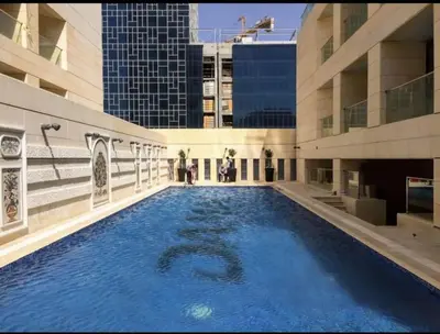 a large swimming pool in the middle of a building at Amman Damac one bedroom boulevard Abdali استديو في داماك عمان الاردن in Amman