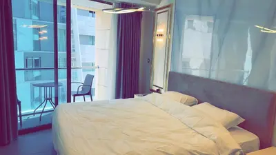 a bedroom with a bed and a balcony with a table at Amman Damac one bedroom boulevard Abdali استديو في داماك عمان الاردن in Amman
