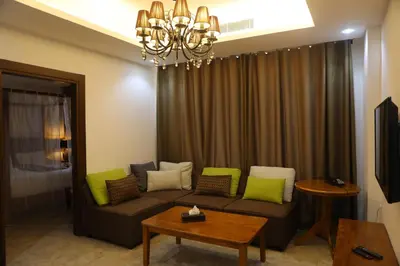 a living room with a couch and a chandelier at Hotel Rayshan in Amman