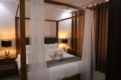 a bedroom with a canopy bed with white curtains at Hotel Rayshan in Amman