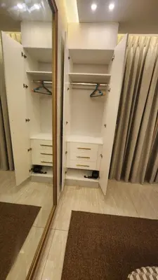 a mirror in a walk in closet with white cabinets at Amazing new apartment in the middle of Amman in Amman