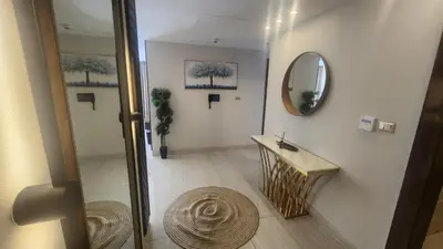 a hallway with a mirror and a table in a room at Amazing new apartment in the middle of Amman in Amman