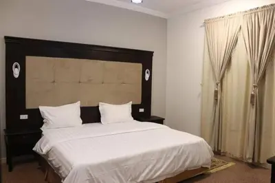 a bedroom with a large bed with white sheets at Jordan House INN in Amman