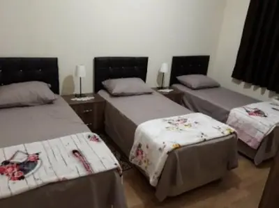 a room with three beds in a room at Jordan House INN in Amman