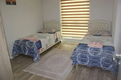 two twin beds in a room with a window at Jordan House INN in Amman