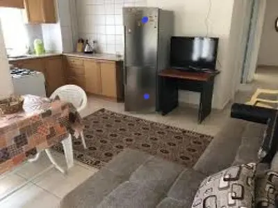 a kitchen with a stainless steel refrigerator and a tv at Jordan House INN in Amman