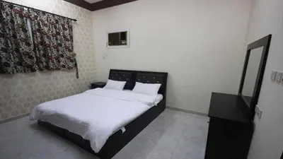 a bedroom with a bed with white sheets and a mirror at 360 INNn in Irbid
