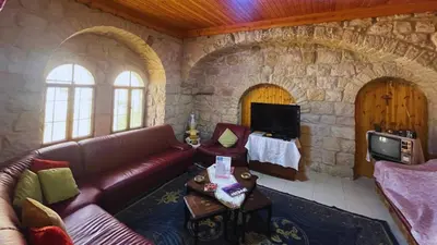 a living room with a couch and a stone wall at Al Karak House sharing Apt in Kerak