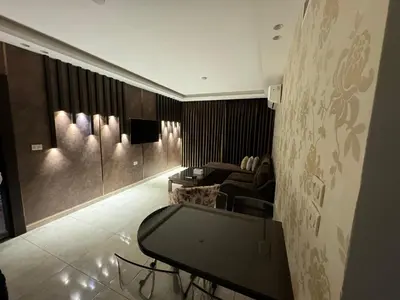 a living room with a table and a couch at COZY apt For long &short Stay in Amman