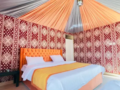 a bedroom with an orange bed in a tent at Fadi camp in Wadi Rum