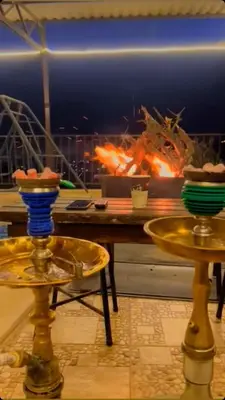 a table with two plates of food on it with a fire at شاليه جبال سوف in Jerash
