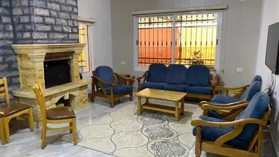 a living room with blue furniture and a fireplace at شاليه جبال سوف in Jerash