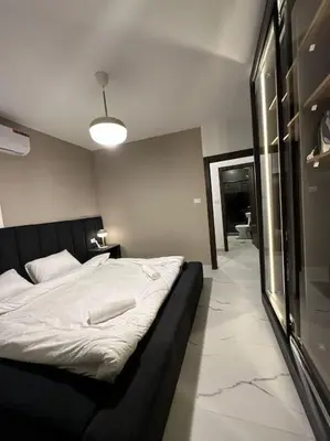 a bedroom with a large bed with a black frame at Stylish Luxe Apartment F-R 0003 in Amman
