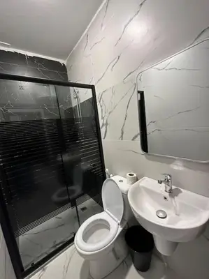 a bathroom with a toilet and a shower and a sink at Stylish Luxe Apartment F-R 0003 in Amman