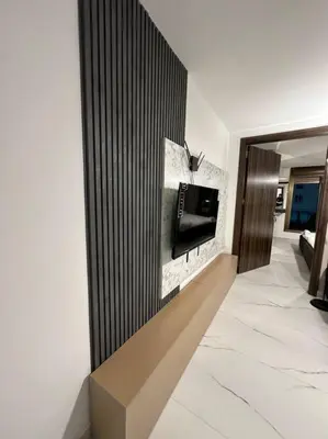 a living room with a tv on a wall at Stylish Luxe Apartment F-R 0006 in Amman