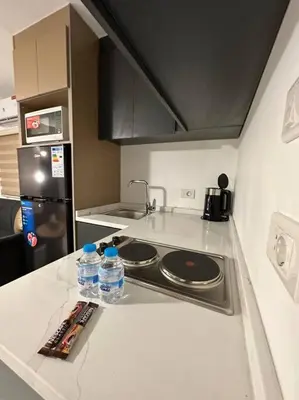 a kitchen with two bottles of water on a counter at Stylish Luxe Apartment F-R 0006 in Amman