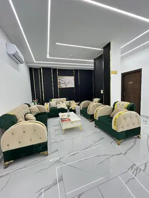 a living room with green couches and a table at Jerash Hotel in Jerash