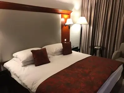 a bedroom with a large white bed with brown pillows at Jerash Hotel in Jerash