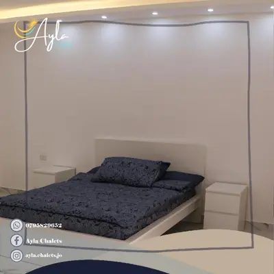 a bedroom with a bed with a glass wall at Ayla Chalets in Amman