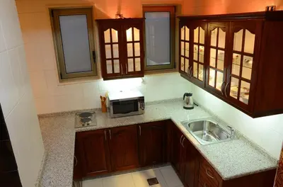 a kitchen with a sink and a microwave at Jad Hotel & Suite in Umm Uthainah