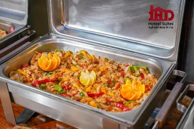 a pan of rice and vegetables in a refrigerator at Jad Hotel & Suite in Umm Uthainah