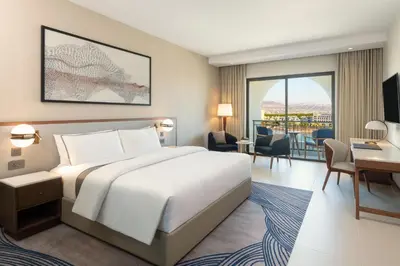 a hotel room with a large bed and a desk and a desk at The Westin Saraya Aqaba Resort & Spa in Aqaba