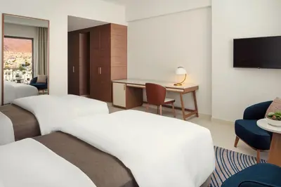 a hotel room with two beds and a television at The Westin Saraya Aqaba Resort & Spa in Aqaba