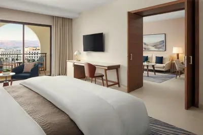 a hotel room with a bed and a living room at The Westin Saraya Aqaba Resort & Spa in Aqaba