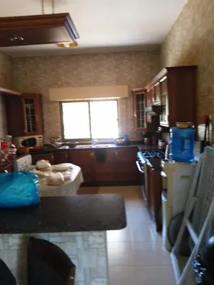 a kitchen with a counter and a stove top oven at Ayola Apartment in Madaba