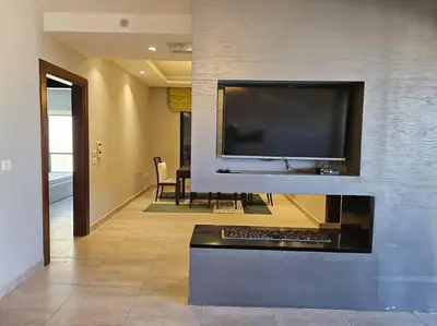 a living room with a large flat screen tv on a wall at Elite Abdoun area, Amman, 2 Br, 5 guests in Umm Uthainah