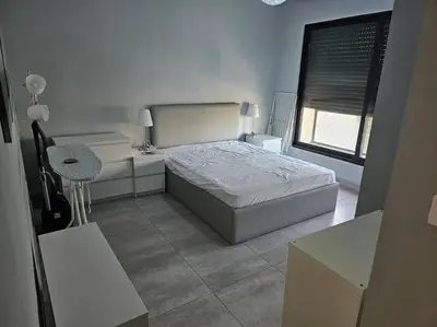 a bedroom with a bed and a desk and a window at Elite Abdoun area, Amman, 2 Br, 5 guests in Umm Uthainah