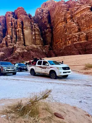 a white truck parked in front of a mountain at Titanic Wadi Rum in Disah