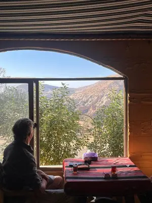 a woman sitting in a window looking out at the mountains at Dana horizon hotel in Dana