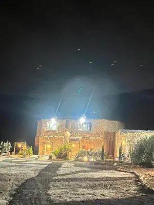 a stone building at night with birds flying in the sky at Dana horizon hotel in Dana