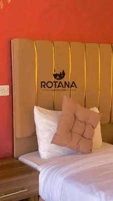 a bed with a wooden bench next to a wall at Rotana luxury camp in Wadi Rum