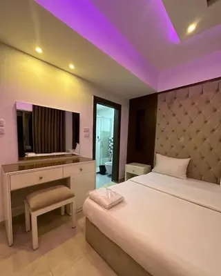 a bedroom with a bed with a desk and a mirror at abdoun rooftop 1bedroom kh&sh 03 in Amman