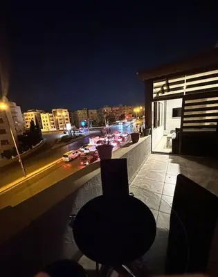 a view of a city at night from a balcony at abdoun rooftop 1bedroom kh&sh 03 in Amman