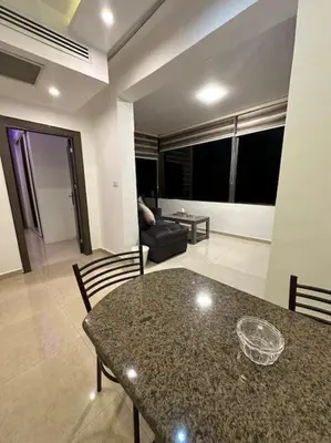 a living room with a table and a couch at abdoun rooftop 1bedroom kh&sh 03 in Amman