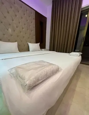 a large white bed with a blanket on it at abdoun rooftop 1bedroom kh&sh 03 in Amman