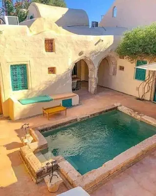a house with a swimming pool in the yard at Chalet Amman Alsayyed in Al Qasţal
