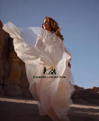 a woman in a white dress running on the beach at Diamond luxury rum in Wadi Rum