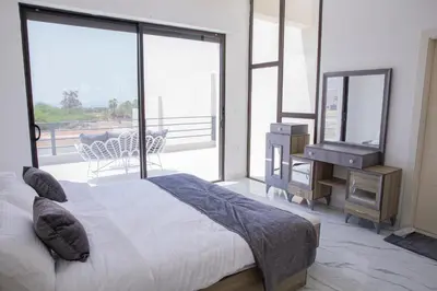 a bedroom with a bed and a mirror and a piano at The Gray Villas in Sowayma