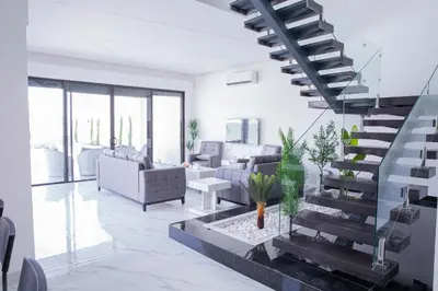 a living room with a spiral staircase in a house at The Gray Villas in Sowayma