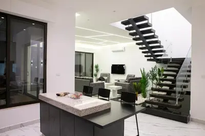 a kitchen and living room with a spiral staircase at The Gray Villas in Sowayma