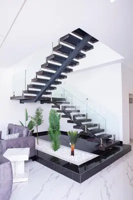 a staircase in a living room with plants at The Gray Villas in Sowayma