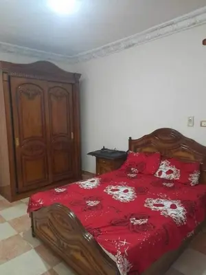 a bedroom with a bed with a red comforter at 3030 Inn in Irbid