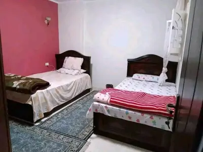 two beds in a room with pink walls at 3030 Inn in Irbid