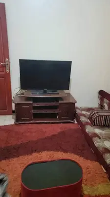 a living room with a flat screen tv and a couch at Go there Inn in Az Zarqa